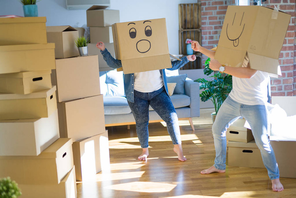 Verrücktes Paar trägt Pappschachteln mit lustigen Emoji-Gesichtern - Foto, Bild