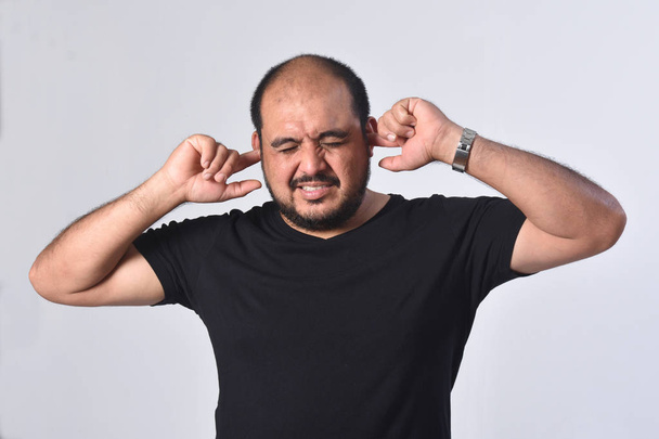 латинский американец, издающий звуки, повреждающие уши на белом фоне
 - Фото, изображение