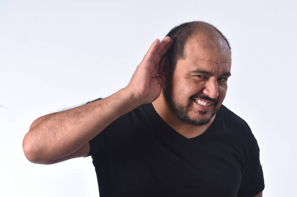 latino-americano homem colocando uma mão em seu ouvido porque ela não pode
 - Foto, Imagem