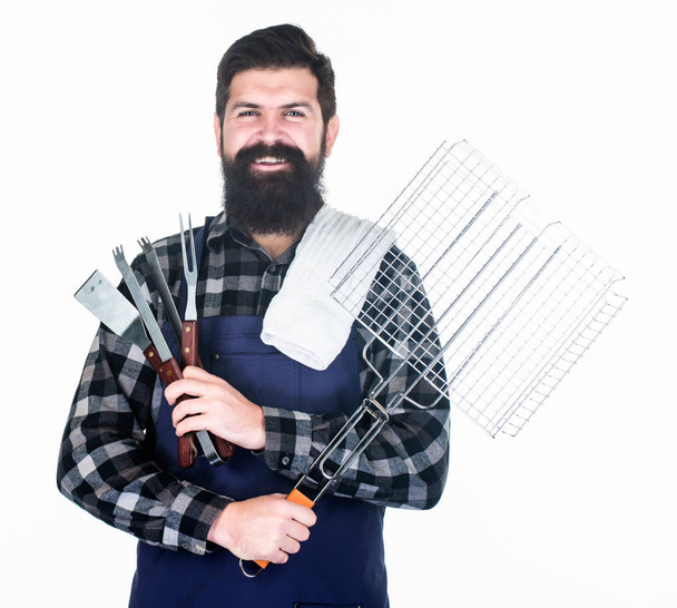 Bearded hipster wear apron for barbecue. Roasting and grilling food. Man hold cooking utensils barbecue. Tools for roasting meat outdoors. Picnic and barbecue. Tips for cooking meat. Barbecue season - Photo, Image