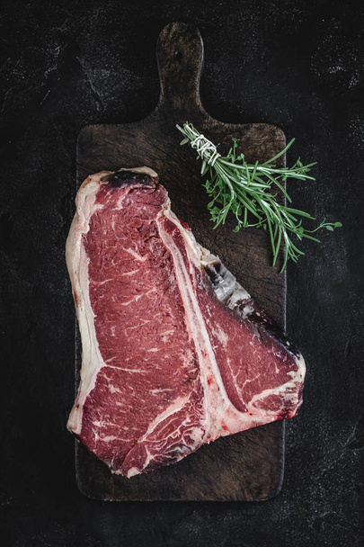Dry Aged Beef Raw T-bone Steak on Vintage Cutting Board - Foto, Imagen