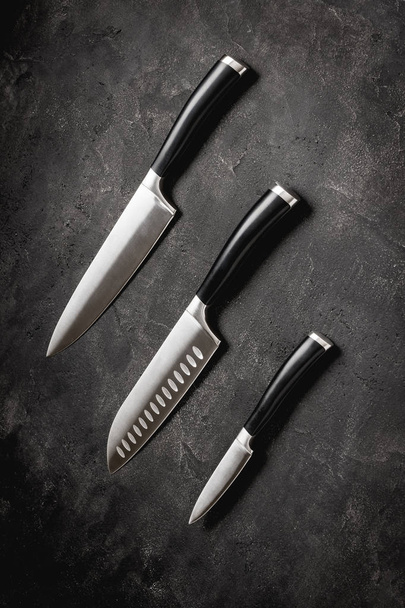 Cuchillos de cocina modernos fijados sobre fondo de piedra. Chef 's Knives Concept
. - Foto, imagen
