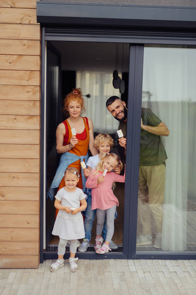 Cheerful nice family standing at the doorstep - Foto, Imagen