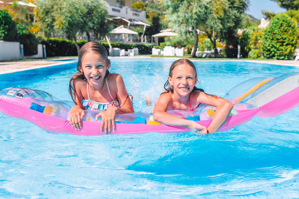 Чарівні маленькі сестри грають у відкритому басейні
 - Фото, зображення