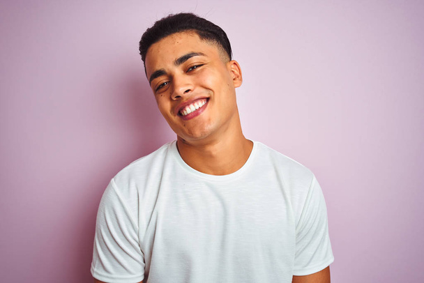 Young brazilian man wearing t-shirt standing over isolated pink background with a happy face standing and smiling with a confident smile showing teeth - Photo, Image