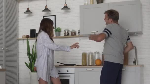 Cheerful dance of man and woman in the kitchen in the morning - Imágenes, Vídeo