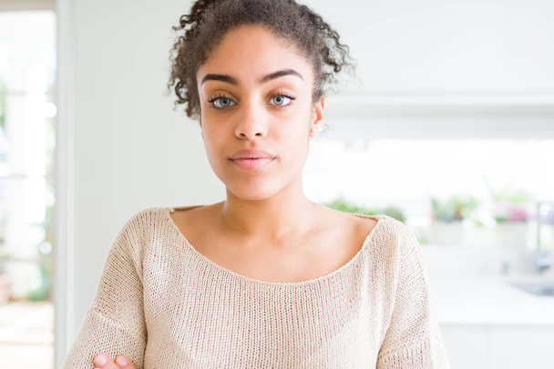 Gyönyörű fiatal afro-amerikai nő, afro haj nyugodt arcán súlyos kifejezés. Egyszerű és természetes keresztezett karokkal - Fotó, kép
