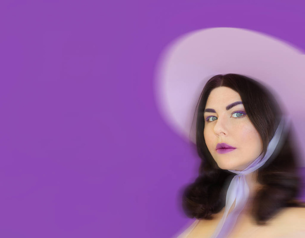 strange funky freaky brunette woman in violet hat with tape on violet background - Photo, Image