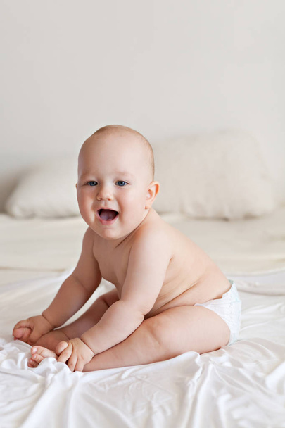 Cute happy 7 month baby boy in bed - Fotoğraf, Görsel