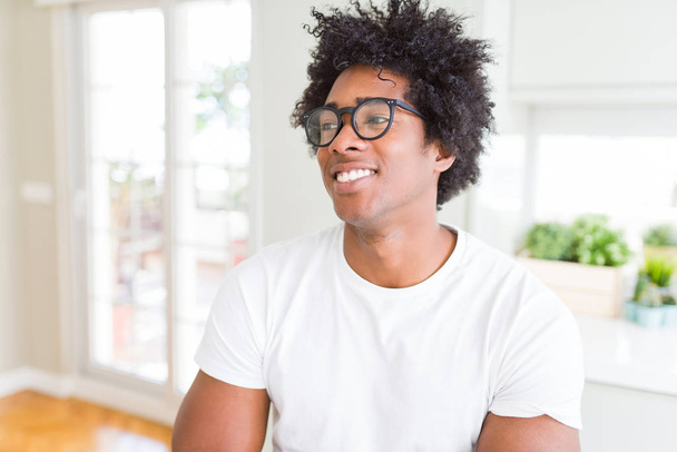 afrikanisch-amerikanischer Mann mit Brille lächelt Seite anschauend und starrt nachdenkend weg. - Foto, Bild