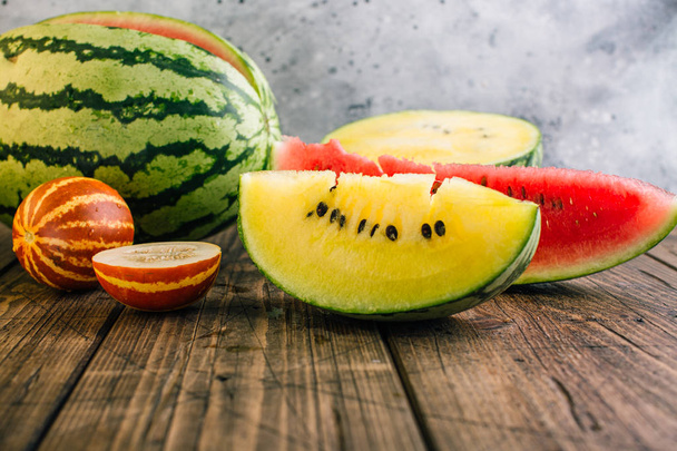 Eri vesimelonit ja meloni, keltainen ja punainen puupohjalla
 - Valokuva, kuva