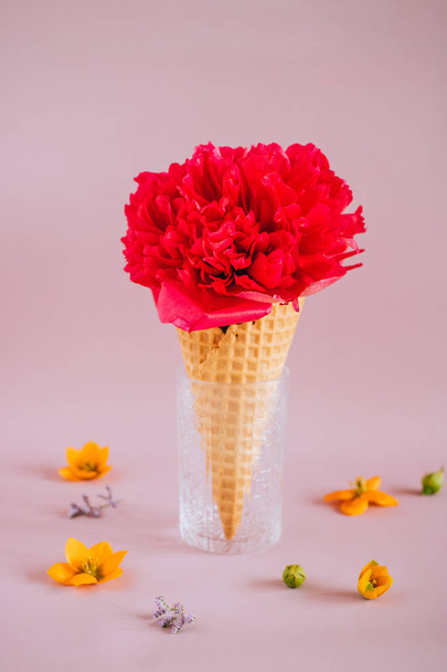 Vaaleanpunainen pioni jäätelössä vaaleanpunaisella taustalla värikkäitä kukkia, kopioi tilaa
 - Valokuva, kuva
