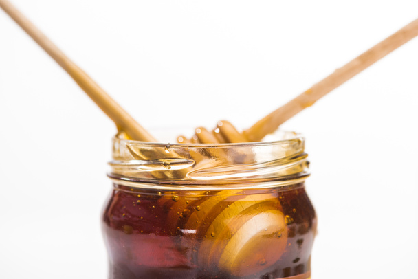 βάζο με μέλι και ξύλινες σταγόνες μελιού απομονωμένα σε λευκό με χώρο αντιγραφής - Φωτογραφία, εικόνα