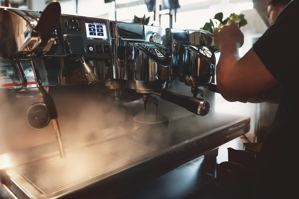 barista man making coffee drink using professional coffee machine steaming around in cafe - Fotoğraf, Görsel