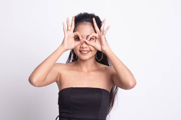 Aasialainen nainen tehdä hauska kaksinkertainen OK merkki kuin lasit
. - Valokuva, kuva