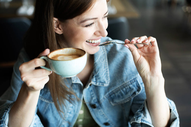chica joven sonriendo y bebiendo delicioso café
 - Foto, imagen