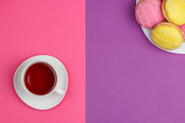 a cup of red tea red and yellow cookies on a pink purple background - Фото, изображение