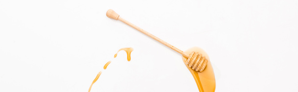 panoramic shot of honey and wooden honey dipper isolated on white  - Photo, Image