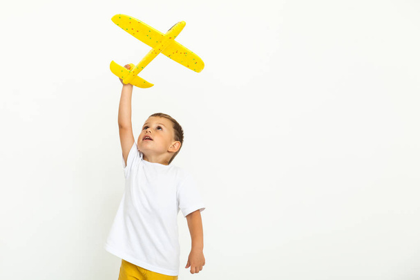ευτυχισμένο παιδί νήπιο παίζοντας με το κίτρινο παιχνίδι αεροπλάνο - Φωτογραφία, εικόνα