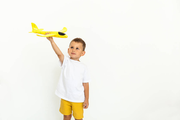 niño feliz niño jugando con el avión amarillo del juguete
 - Foto, Imagen