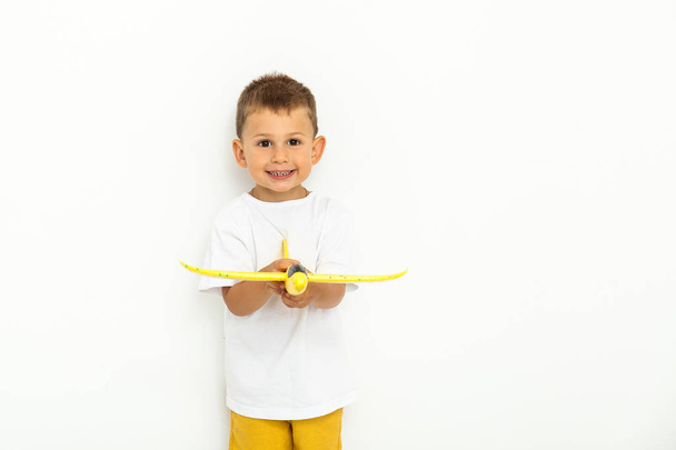 boldog gyermek tipegő játék sárga játék repülőgép - Fotó, kép