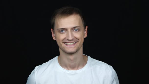 portrait of satisfied confident caucasian man looking on camera smiling nodding positively over black background. Concept of emotions - Footage, Video
