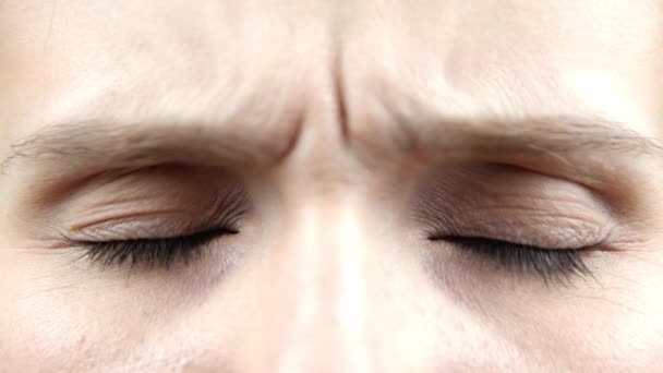Close-up van een vrouwelijke ogen. Detail van het openen van een blauwe ogen van een vrouw die naar de camera kijkt. Ongelukkig en verdrietig blanke vrouwelijke wakker op zoek - Video