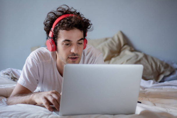man using his laptop in bed - Foto, Imagen
