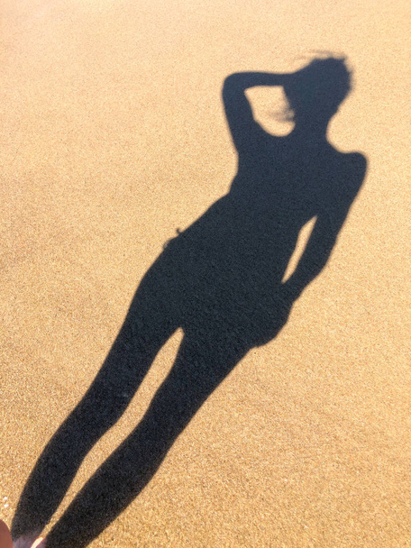Young woman shadow on a sand - Fotó, kép