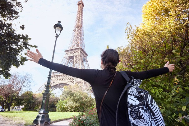 Bella ragazza sorridente posa con le braccia spalancate sullo sfondo della Torre Eiffel. Parigi, Campione di Marte
 - Foto, immagini