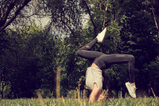 Bonito esportivo ajuste yogi mulher práticas ioga suporte asana Bhuja Vrischikasana - postura de suporte de escorpião
 - Foto, Imagem