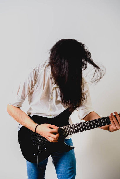 Гітарист позує зі своєю електрогітарою, білим тлом
. - Фото, зображення