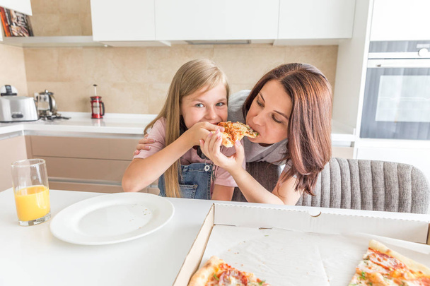 Мати і дочка їдять смачну піцу
 - Фото, зображення