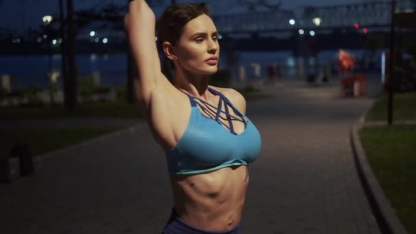 Stretching voor de training. jonge slanke vrouw warmt op voor de avond training - Video