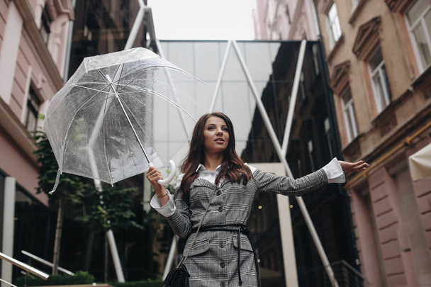 Porträt einer glücklichen Frau unter einem Regenschirm in der Nähe des Büros, wai - Foto, Bild