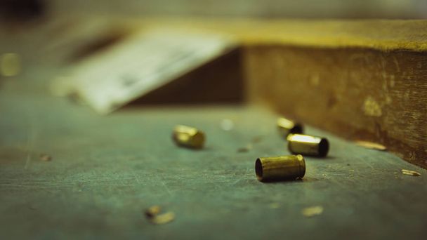 Порожні снаряди для пістолета на дерев'яному столі в діапазоні стрільби
 - Фото, зображення