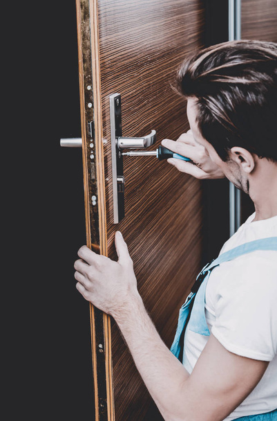 man changes the lock in the door - Valokuva, kuva