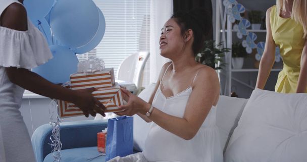 Amico che fa un regalo alla madre incinta
 - Foto, immagini