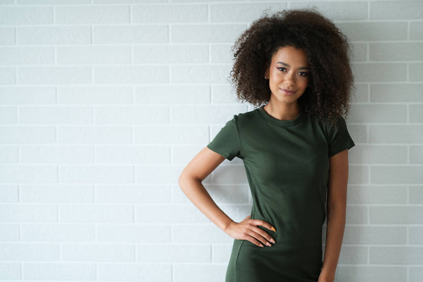 Φυσική ομορφιά Αφρο γυναίκα σε απλό πράσινο φόρεμα. - Φωτογραφία, εικόνα