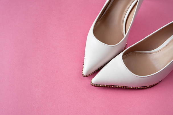 Light white high heels isolated on a bright pink pastel background. Fashion concept - Photo, Image