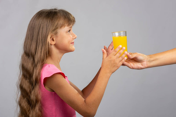 De hand houdt een glas jus d'orange - Foto, afbeelding