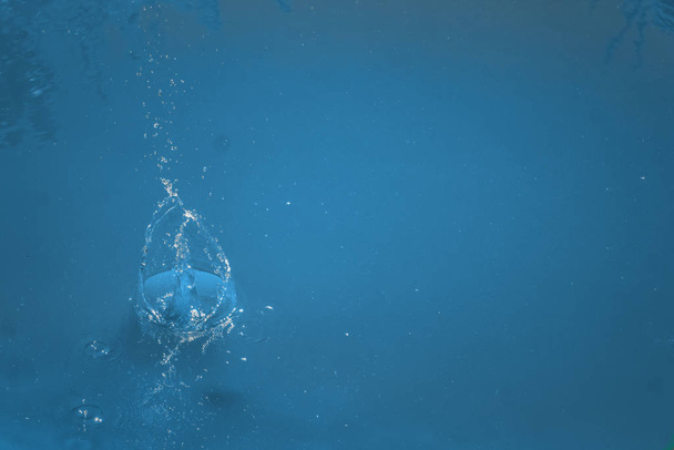 Blue background, motion details showing it is a liquid. - Photo, Image