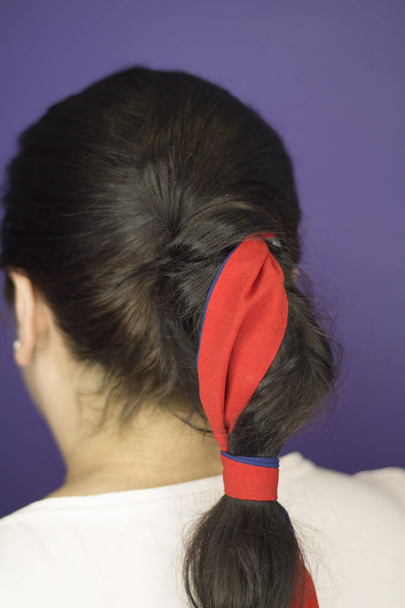 Woman with pigtail decorated with a red bow - Photo, Image