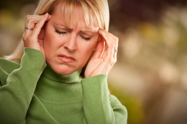 Mujer con muecas que sufre un dolor de cabeza
 - Foto, Imagen