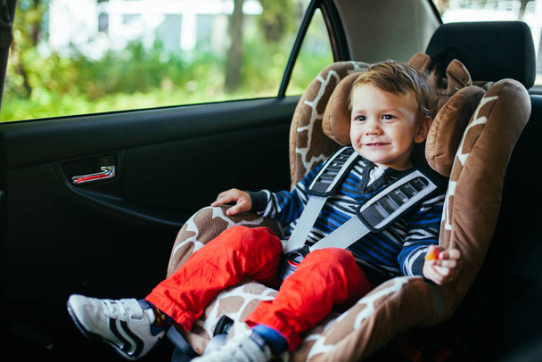Adorable baby boy in a safety car seat. - Фото, изображение