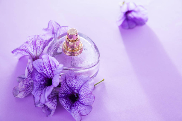 Ένα μπουκάλι άρωμα με λουλούδια. Λουλουδάτο άρωμα. Βιολογικά καλλυντικά - Φωτογραφία, εικόνα