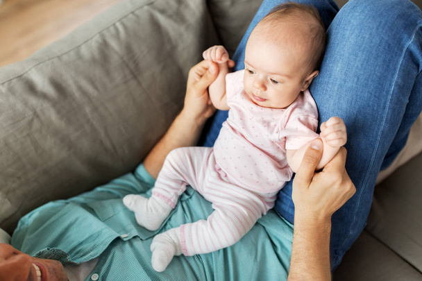middle aged father with baby lying on sofa at home - Photo, Image