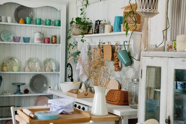 Stylish and sunny interior of kitchen space with small wooden table at the photo studio. Scandinavian room decor with kitchen accessories. - 写真・画像