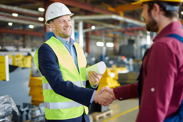 Engineer and foreman shake hands after successfully discussing a new project. - Zdjęcie, obraz