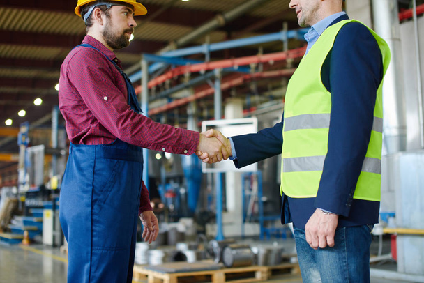 Engineer and foreman shake hands after successfully discussing a new project. - Photo, Image
